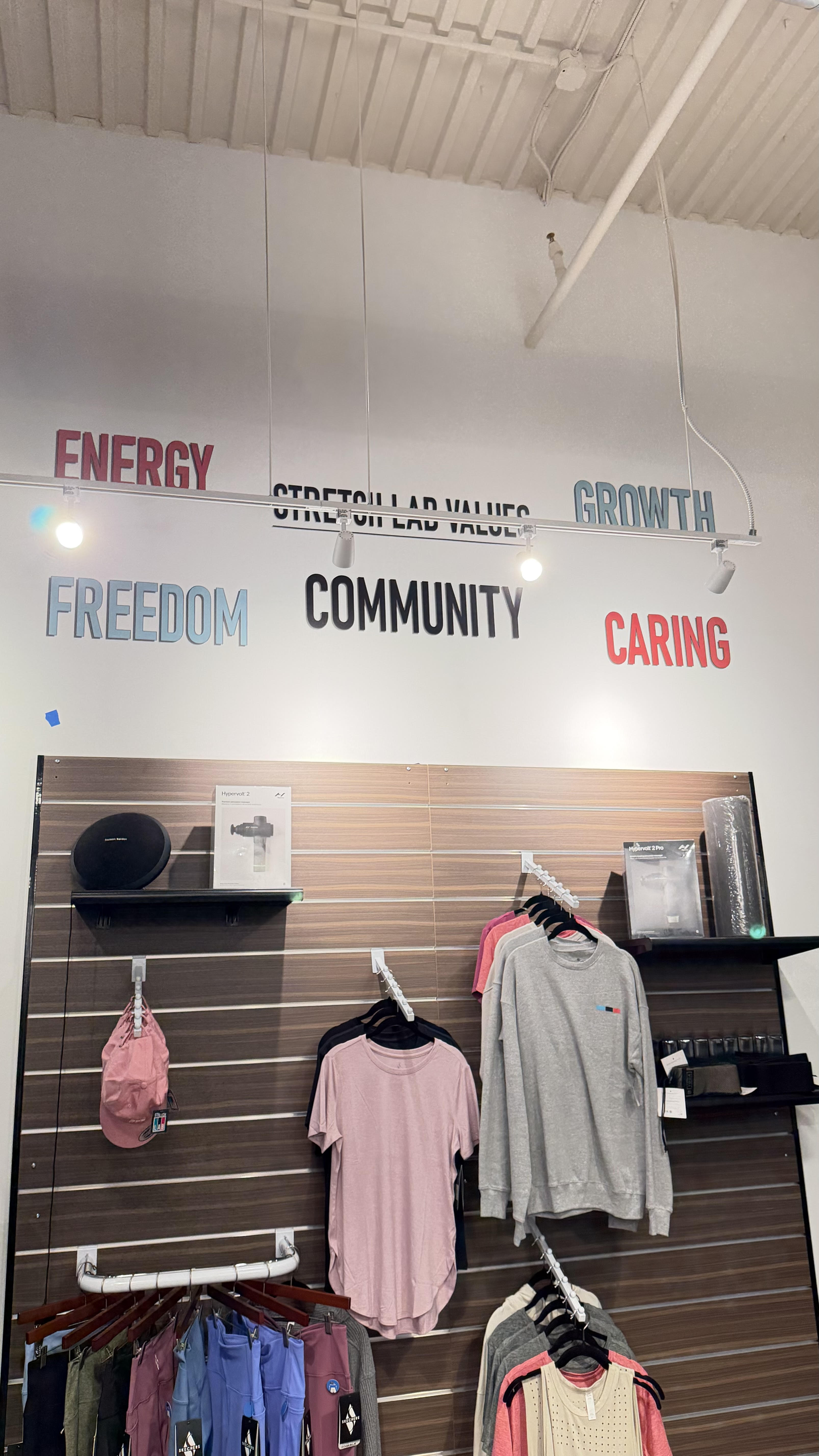 StretchLab brand values printed high on a wall above a retail display